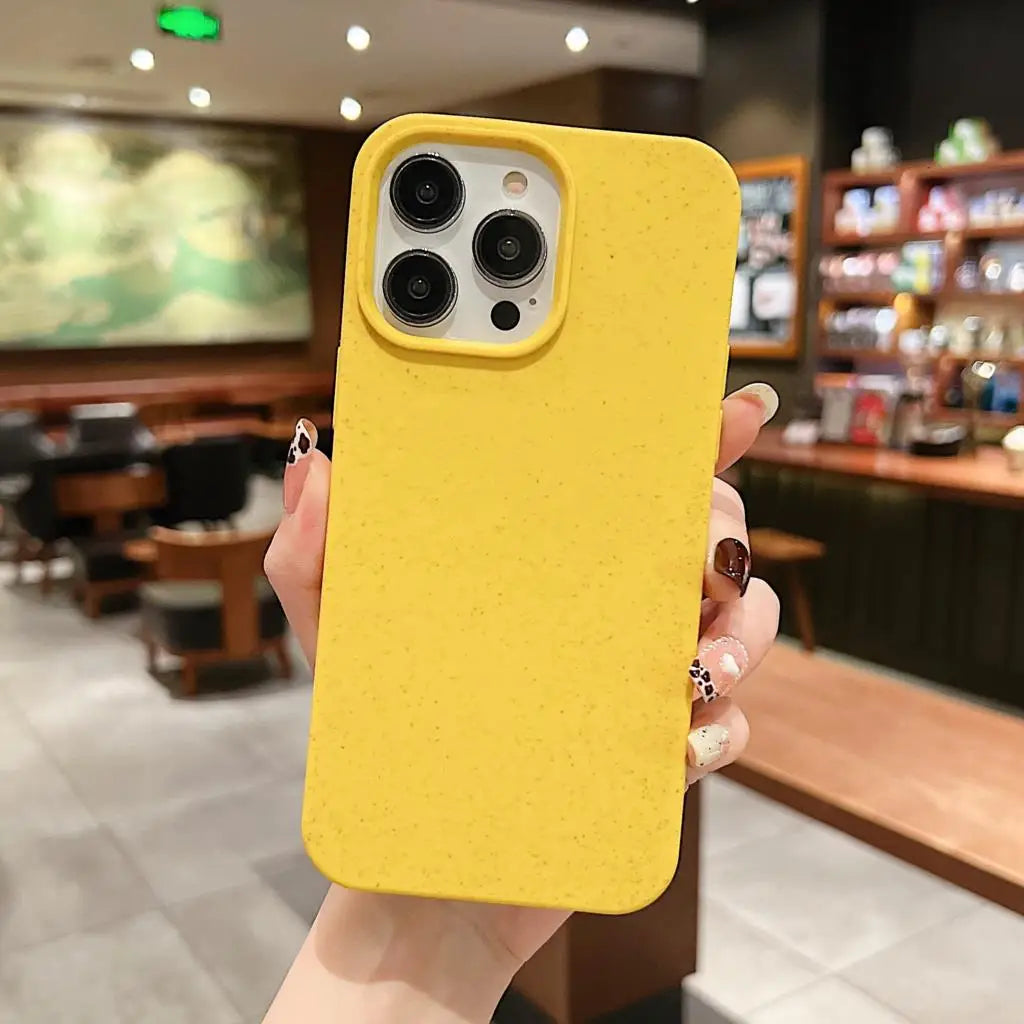 Gelbe iPhone Hülle aus nachhaltiger Silikon-Weizenstroh-Mischung, fotografiert in Café-Umgebung