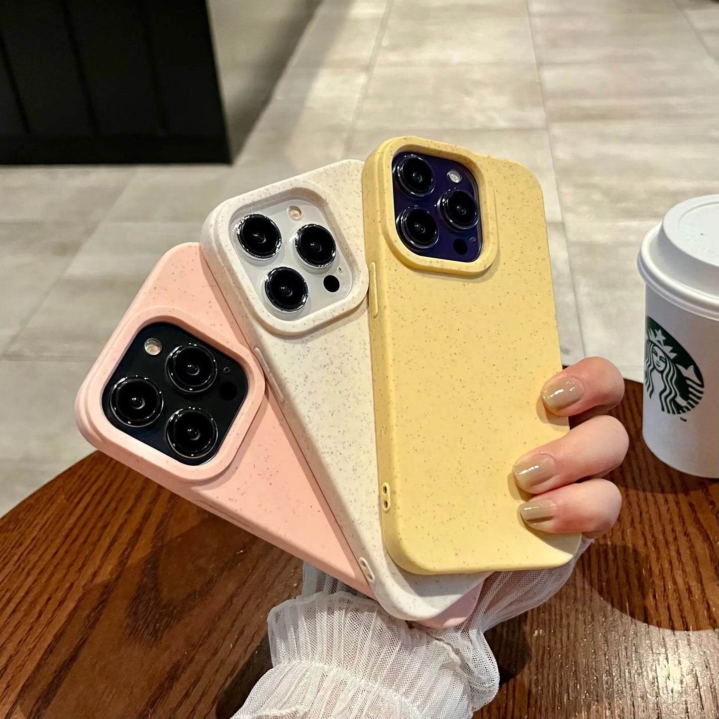 Nachhaltige iPhone Hüllen in Rosa, Weiß und Gelb aus Silikon-Weizenstroh-Mischung, in Hand gehalten