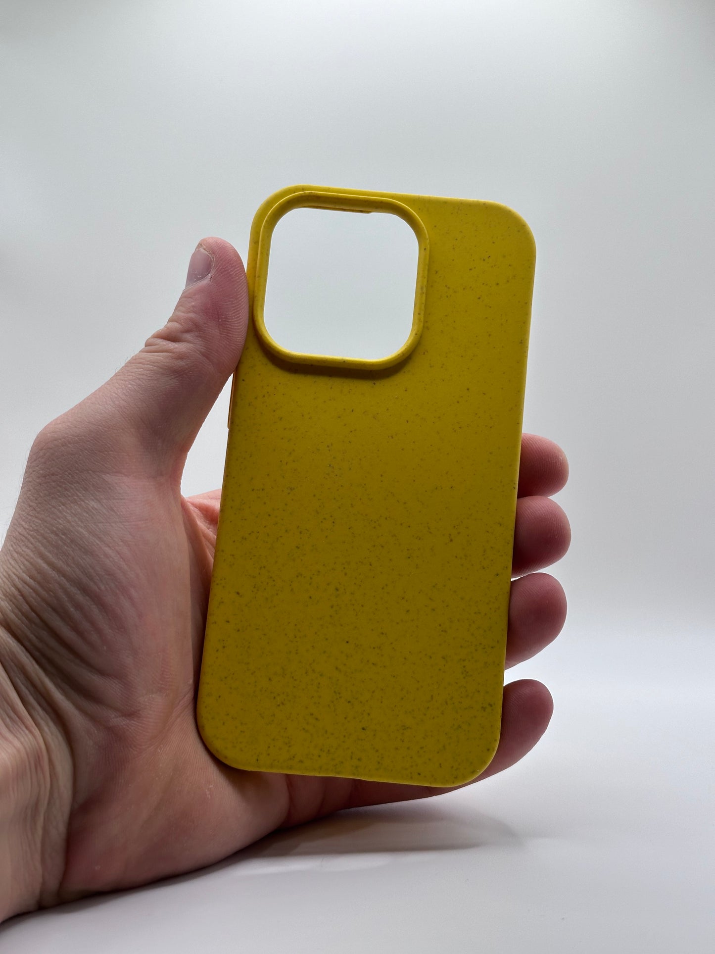 Gelbe iPhone Hülle aus biologisch abbaubarem Silikon, gehalten vor weißem Hintergrund
